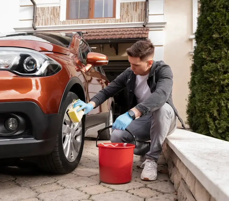 Lavage auto à domicile Saint-Germain-le-Guillaume : professionnel intervenant sur un véhicule